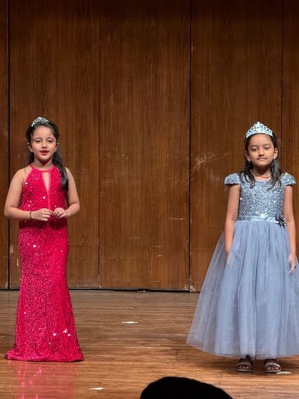 Two princesses share the stage, their sparkling dresses matching their shining confidence.