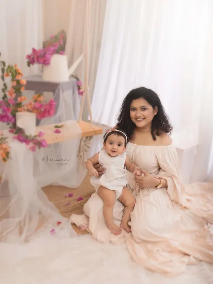 A mother and her baby girl sit together in our spring-themed setup, surrounded by bougainvillea. A beautiful portrait celebrating her first year.