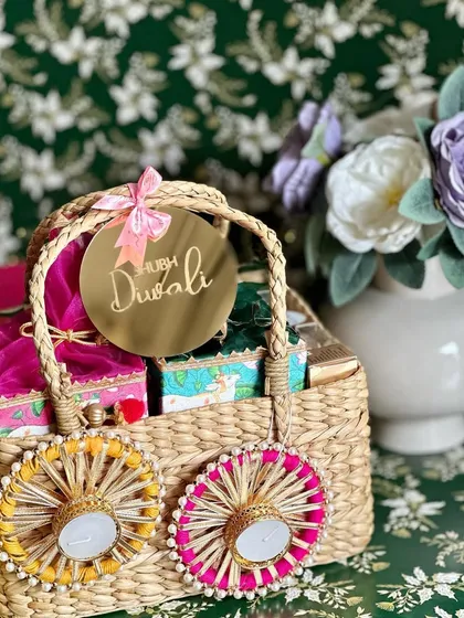 A unique and eco-friendly Diwali gift. This Kauna grass basket includes a plantable cracker box, pichwai potli boxes with dry fruits and potpourri, and decorative tealight holders, making it a gift that keeps on giving.