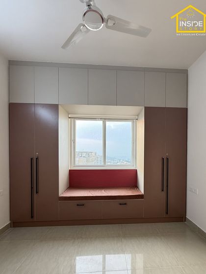 Another view of the master bedroom, showcasing the cozy window seat with a pop of color. The surrounding wardrobes provide ample storage, making the room feel spacious and uncluttered.