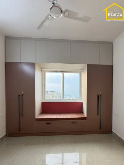 Another view of the master bedroom, showcasing the cozy window seat with a pop of color. The surrounding wardrobes provide ample storage, making the room feel spacious and uncluttered.