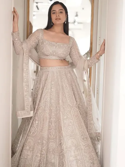 Dazzle in heritage elegance. This intricately embellished white lehenga is a masterpiece of traditional craftsmanship.