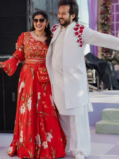 The couple enjoying the festivities. This photo shows how their outfits work together in a candid setting, creating a cohesive and stylish look that feels effortless.