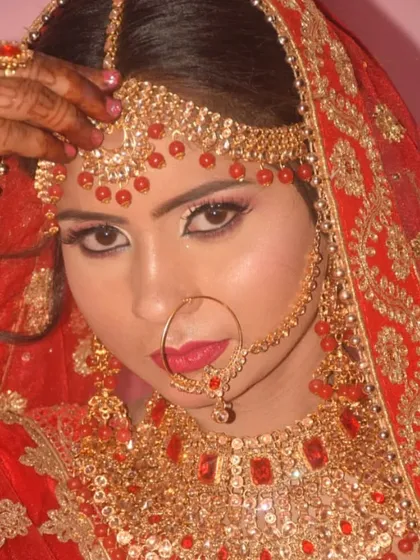A close-up of a bride with dramatic eye makeup and bold red jewellery. This look is perfect for brides who want to make a statement.