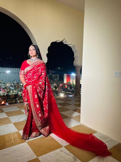 A full view of Kavya's breathtaking red saree look. The long, trailing veil adds a touch of drama, while her makeup remains timeless and elegant.