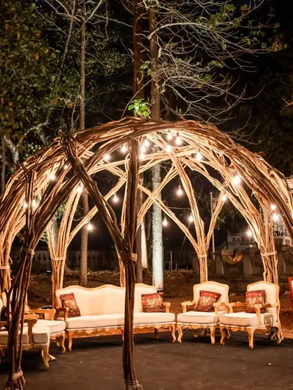 A rustic yet elegant seating dome made of woven branches and lit with Edison bulbs. This created a cozy and whimsical lounge area for guests to relax in during the evening.