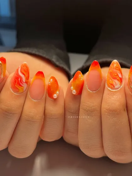 Can't get enough of this fiery marble set. It features a warm orange and white marble effect, accented with gold chrome swirls and delicate pearls.