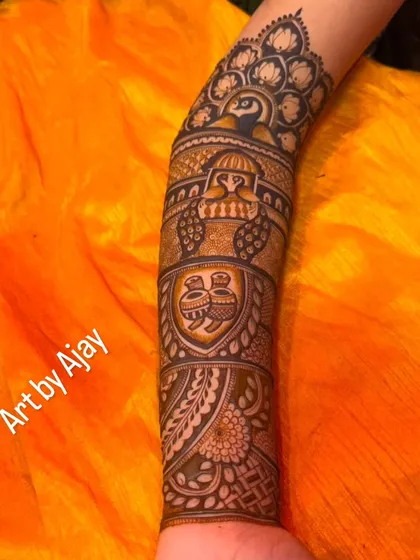 An arm design featuring a peacock, kalash pots, and other traditional Rajasthani elements.