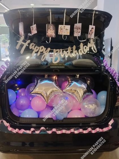 A surprise car boot decoration filled with balloons, photos, and a "Happy Birthday" banner.