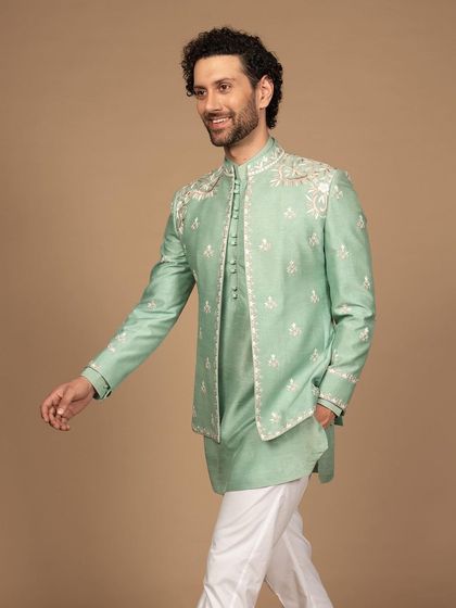 Elegance redefined. This luxurious bandhgala in a fresh mint green features delicate white embroidery on the shoulders and cuffs, offering a perfect blend of color and craftsmanship.