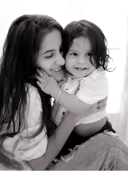A sweet, smiling hug between a mother and her son. This black and white portrait has a timeless feel, focusing on their happy and loving bond.