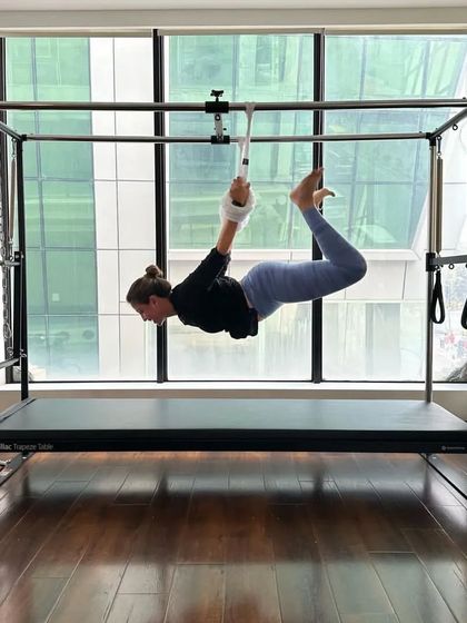 A client enjoys the challenge of the Cadillac. The variety of equipment keeps workouts exciting and pushes you to new fitness heights.