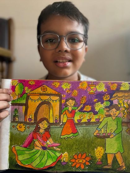 A student holds his detailed Diwali drawing, capturing a family celebrating with diyas and rangoli. This piece beautifully illustrates the joy of the festival of lights.