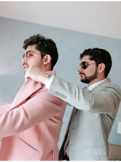 A best man helping the groom get ready. A moment of friendship and support before he says 'I do'.