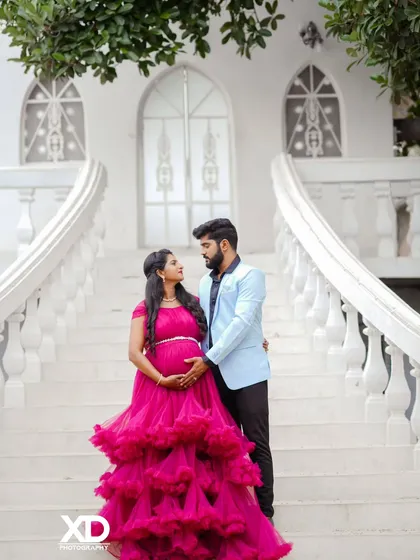 A romantic portrait of a couple on a grand white staircase, capturing a moment of quiet intimacy.