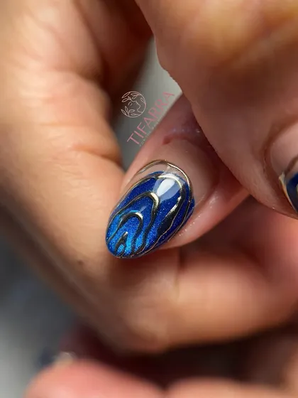 A single nail from the ocean luxury set, showing the detailed chrome work over the sparkling blue base.