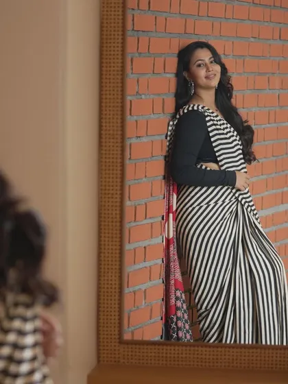 A modern take on saree styling. This look, featuring soft, flowing curls and natural makeup, shows how we can create a contemporary and chic style for photoshoots, corporate events, or family get-togethers.