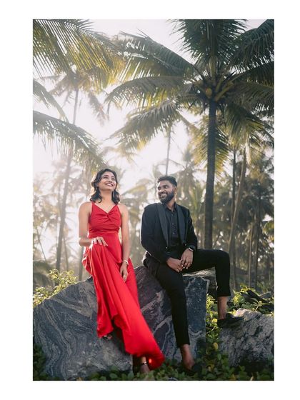The couple poses against a backdrop of palm trees, capturing the golden hour light and the tropical feel of their anniversary shoot.