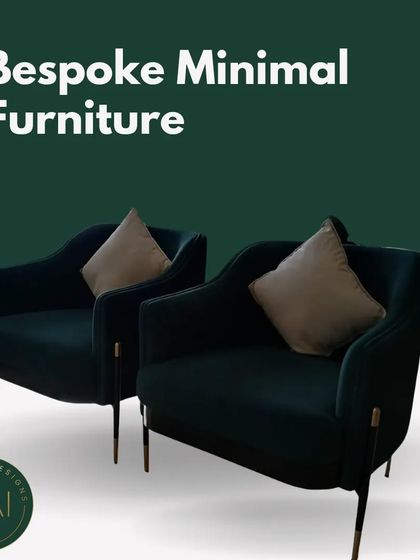 A pair of minimalist armchairs in a deep emerald green velvet with delicate metal legs. These chairs offer a sleek, contemporary look while providing comfortable and stylish seating.