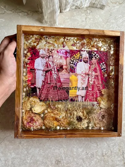This 12-inch teakwood frame showcases two wedding photos surrounded by preserved varmala flowers and pearls. It’s a beautiful way to display multiple cherished moments from your special day.