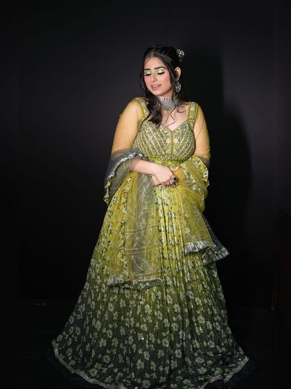 A full-length shot against a black background, making the green color and floral print stand out.