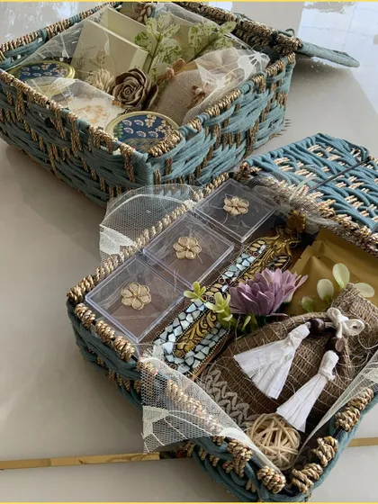 Our stunning blue jute hamper is a blend of natural beauty and luxurious charm. This image shows the box open, revealing a curated selection of gifts inside.