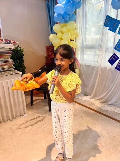 A young girl confidently holds the microphone during the open mic session at our Lit Fest, sharing her story with the audience.