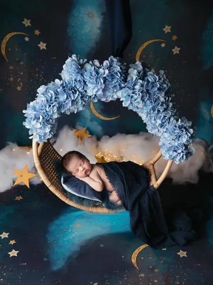 Let's fly to the moon and play among the stars. I love creating magical, dreamy worlds for your little ones. This celestial theme with a starry backdrop and a floral moon swing makes for an enchanting newborn portrait.