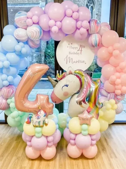 A full view of the pastel unicorn balloon ring for Marnie's 4th birthday, featuring a large unicorn foil balloon as the centerpiece.
