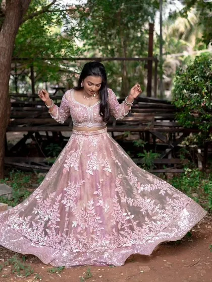 A full-length shot of a model twirling in a beautiful pink lehenga, perfect for a reception or pre-wedding shoot.