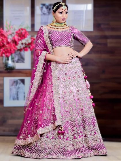 This magenta and purple lehenga is a vibrant and unique choice for the modern bride. The intricate embroidery and bold colors ensure you'll be a memorable bride.