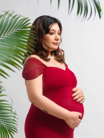 A touch of the tropics. For mothers who love nature, I can bring the outdoors in. This portrait uses fresh palm leaves to frame the mother in her bold red dress, creating a vibrant, tropical feel.