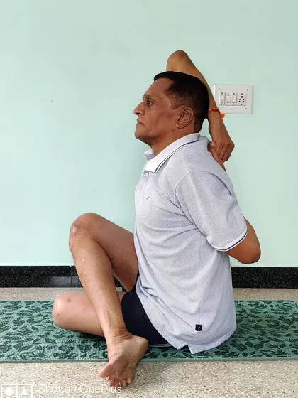 Gomukhasana (Cow Face Pose), side view. This profile view highlights the importance of maintaining an upright posture and lifting the chest.