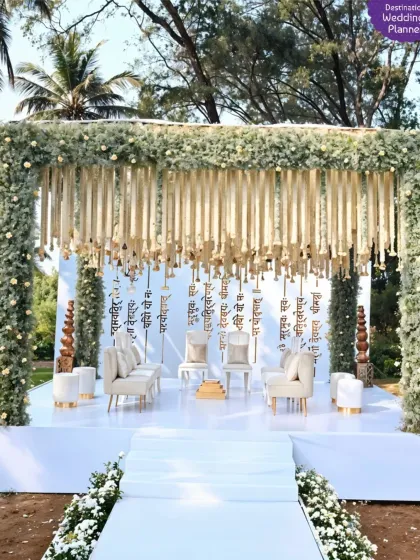 True luxury is in the details. This elegant mandap setup features a canopy of lush greenery and cascading white florals, creating a serene and sophisticated atmosphere for a daytime ceremony. It's about smart design, not just excess.