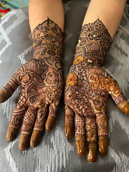 A heavy henna design with personalized initials (R and D) and shaded flowers.