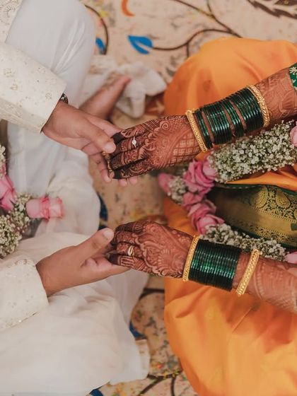 A close-up of the bride and groom's hands during a wedding ritual, symbolizing their union. This detail shot highlights the traditions and the beautiful henna designs.