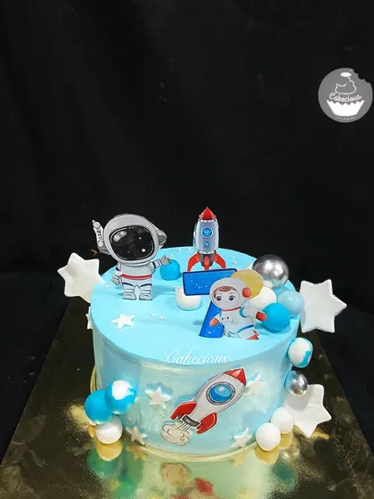 An out-of-this-world astronaut theme cake. This creation is perfect for a space-loving kid, featuring little astronauts, rockets, and stars against a blue galaxy backdrop.