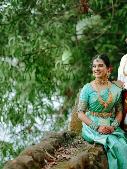 Another angle of the couple enjoying a quiet moment by the lake. The lush green surroundings provide a perfect, tranquil backdrop for their portrait.