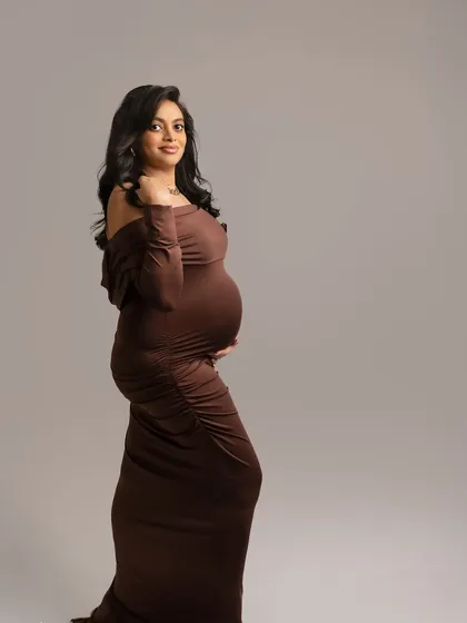A simple, elegant profile in a rich brown gown. This classic pose is all about the silhouette and the quiet confidence of the mother-to-be.