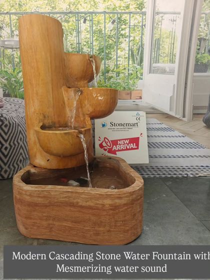 The modern cascading fountain in Teak Sandstone, shown with its mesmerizing water flow. The design directs water through three carved bowls into the main reservoir.