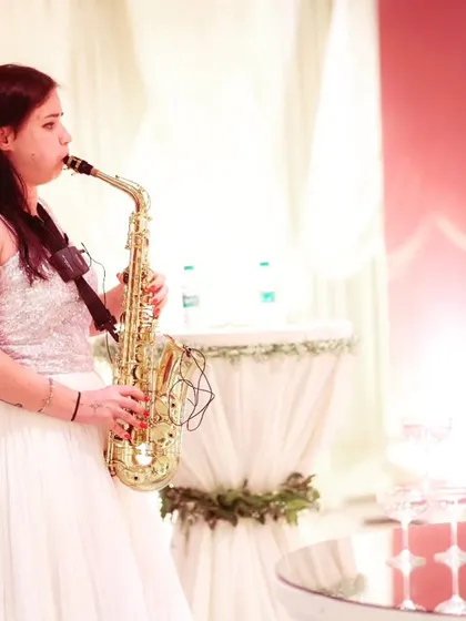 Live entertainment adds a touch of class. A saxophonist performs next to a champagne tower, creating a sophisticated and celebratory atmosphere.