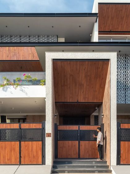 A grand, double-height entrance portal clad in wood makes a powerful statement and provides a sheltered transition into the home.