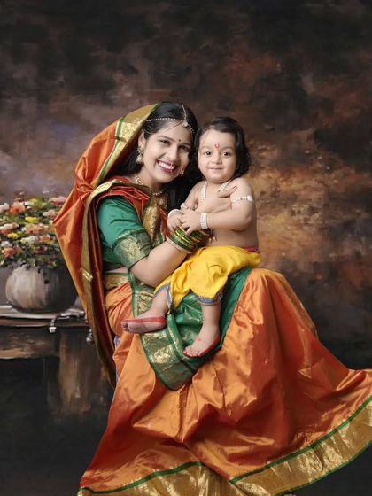 A beautiful portrait of a mother, dressed as Yashoda, holding her little one styled as baby Krishna. This is a wonderful example of a themed mother-child photoshoot.