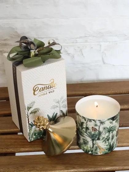 Our Jungle Wild scented candle, featuring a lush print and a chic gold pineapple lid. It comes beautifully packaged, making it a perfect tropical-inspired gift.