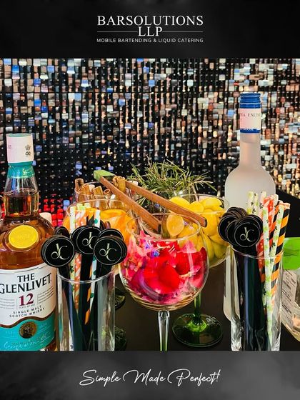 The bar top at an exclusive private party, showcasing premium spirits like The Glenlivet 12 and a beautiful array of fresh garnishes and custom stirrers.