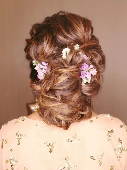 A hairstyle is just as important as the makeup. This intricate, textured bun woven with delicate flowers is the perfect example of how I collaborate with talented hairstylists to complete your look.