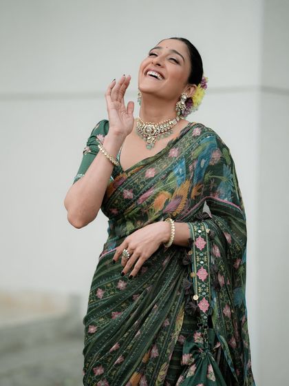 A joyful, candid moment captured during an Onam-themed shoot. The laughter and movement bring a sense of life and celebration to this traditional portrait.