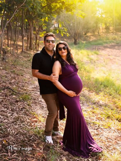 A cool and confident couple's pose in the woods. The sunglasses and their relaxed stance give this outdoor shot a modern and stylish feel.