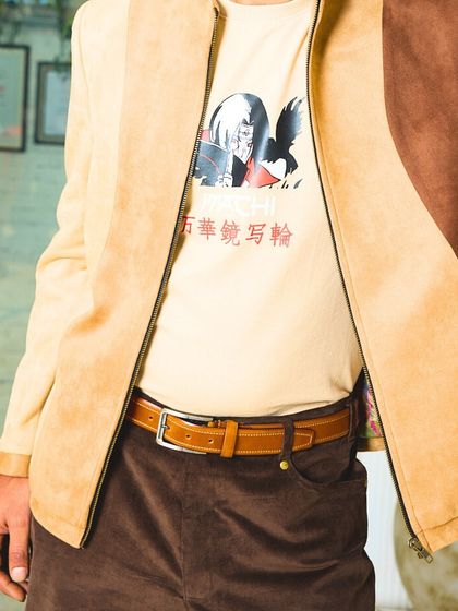 A close-up of the two-toned suede jacket, focusing on the smooth texture of the fabric and the clean lines of its construction.