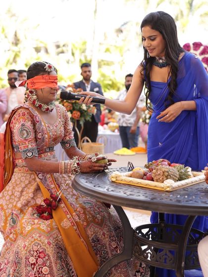 A blindfold game with the bride during her Haldi ceremony. These games are all about creating fun, light-hearted moments centered around the couple.